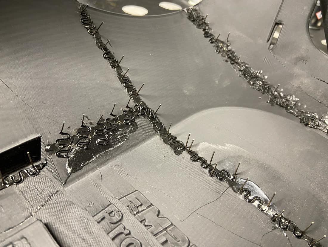 Panel seams stitched with wire staples during plastic welding